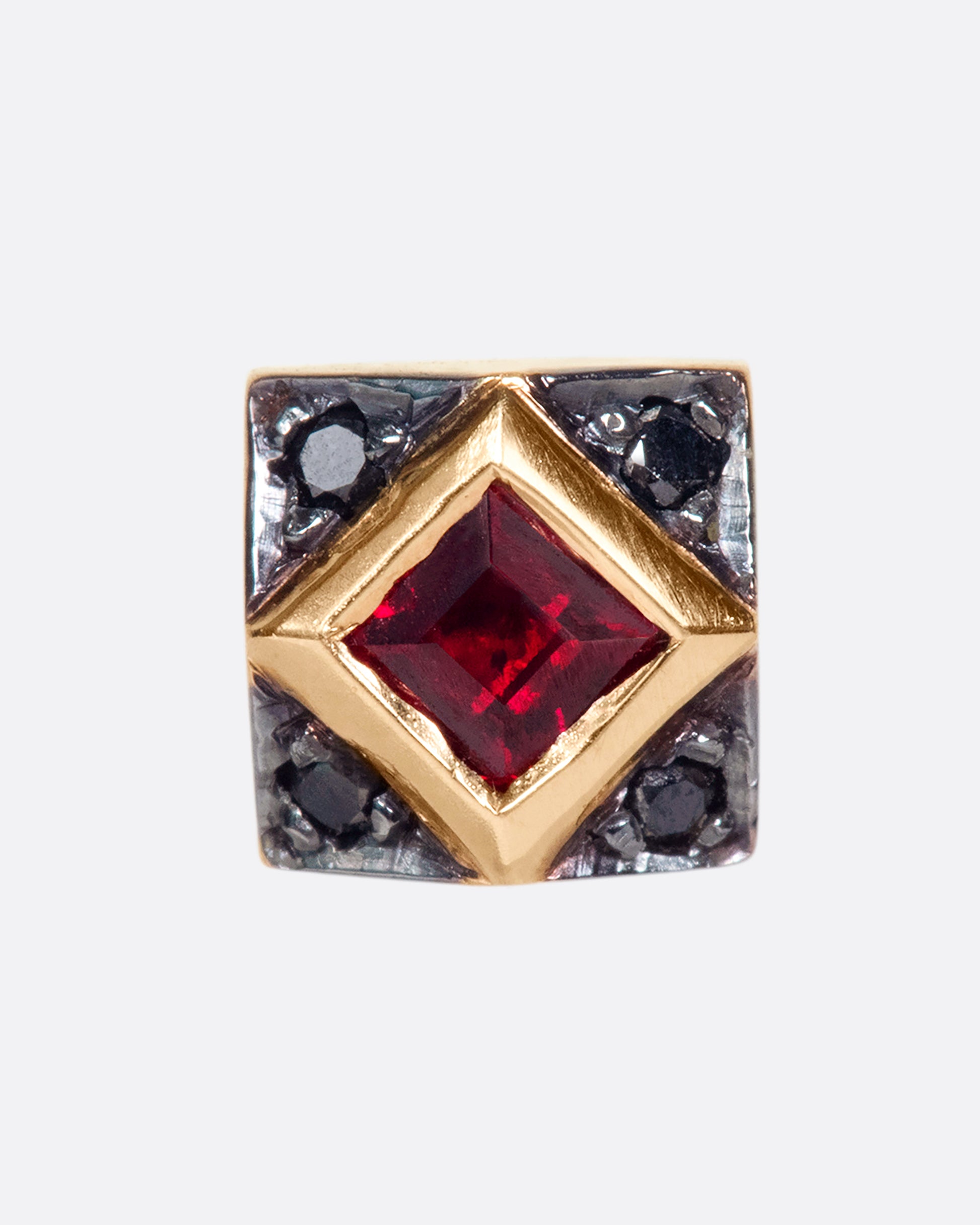 A 14k rose gold diamond stud featuring a princess cut ruby surrounded by four black diamonds