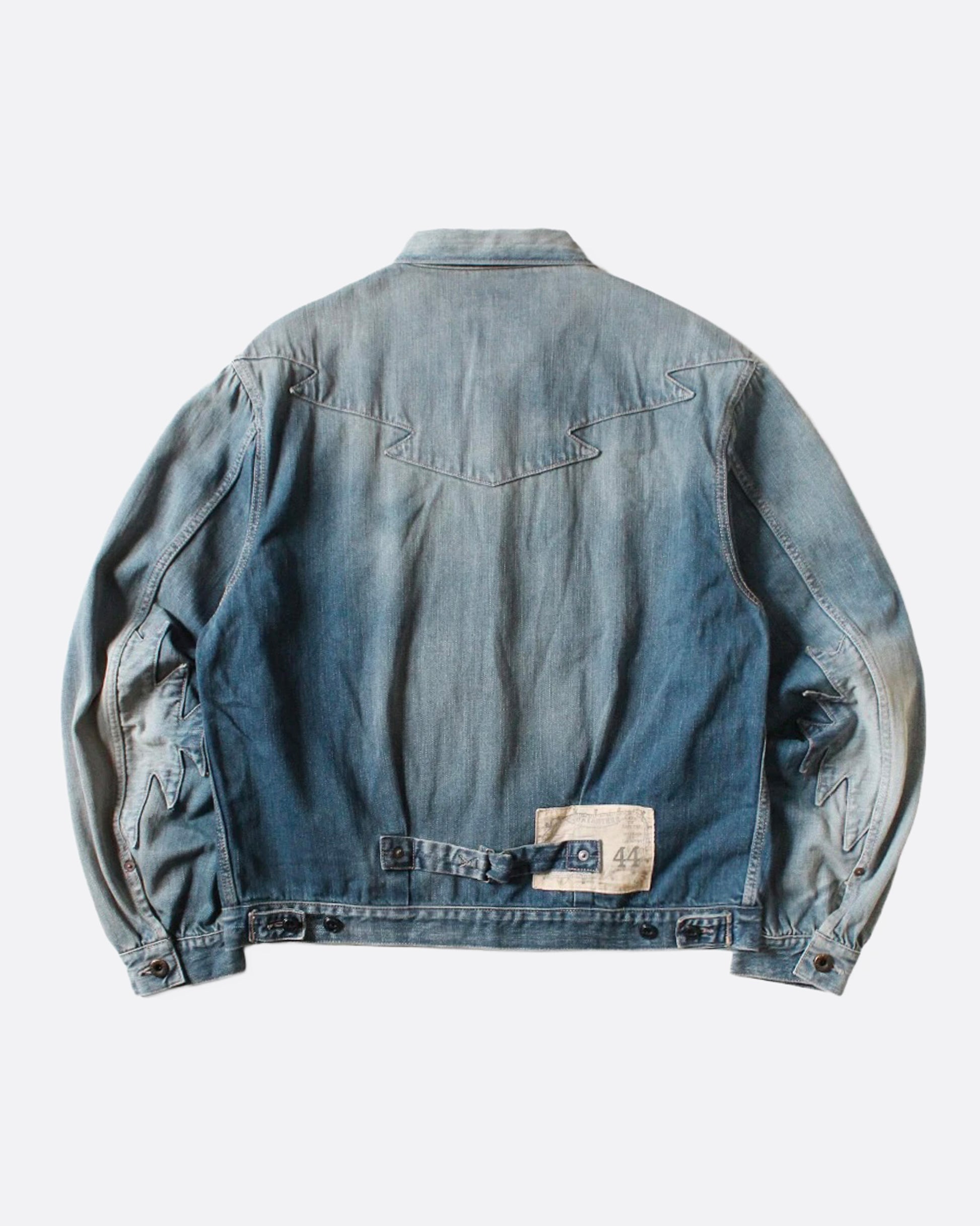 A light blue denim jacket with Chimayo-inspired embroidery across the chest and at each elbow, button closures, and functional back cinch. Shown from the back.