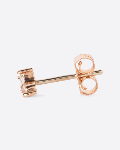 A yellow gold stud earring with a princess cut diamond stacked on top of a round diamond. Shown from the side.