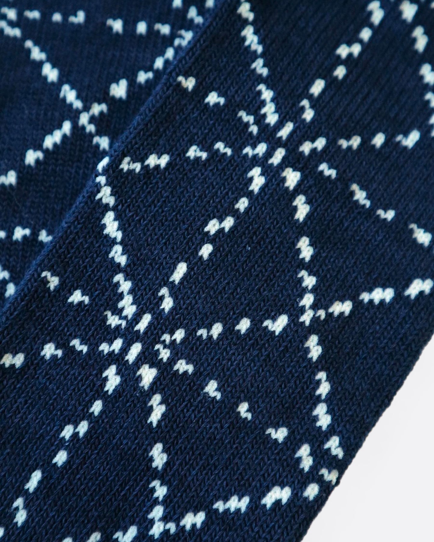 A close up of a navy blue sock with a Japanese sashiko print.