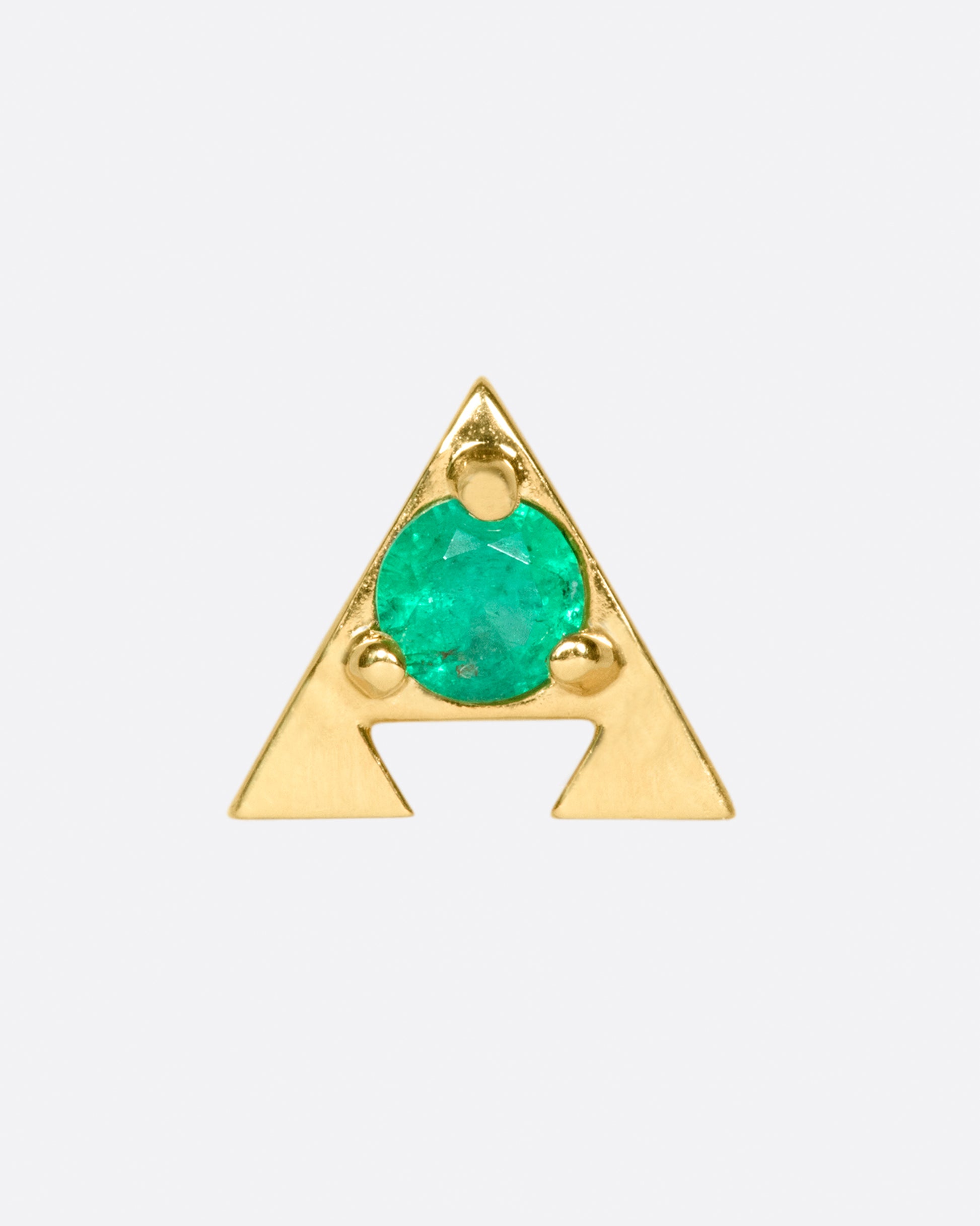 A 14k gold amulet stud with an emerald in the center