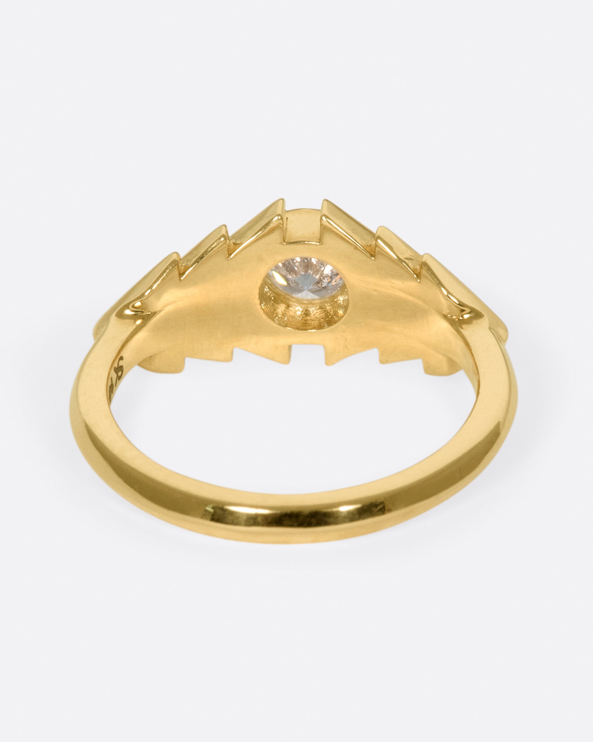 This ring takes cues from tribal kilim pieces, featuring a round diamond contrasting with a repetitive triangular motif