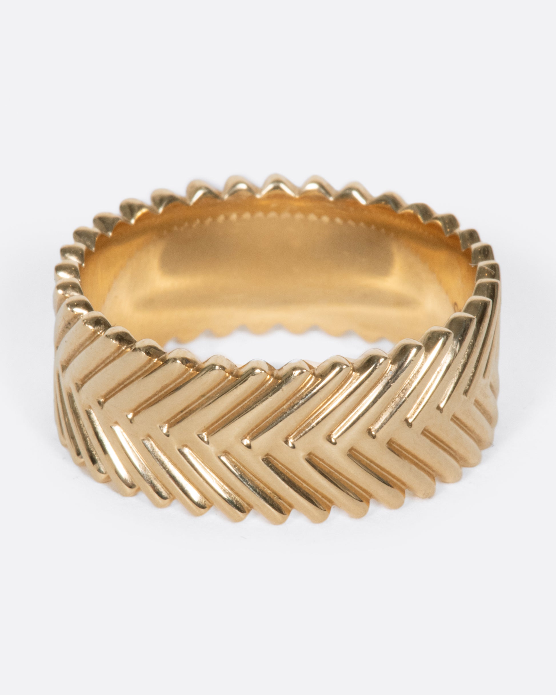 A yellow gold band ring with a braid-like texture, by Selin Kent.