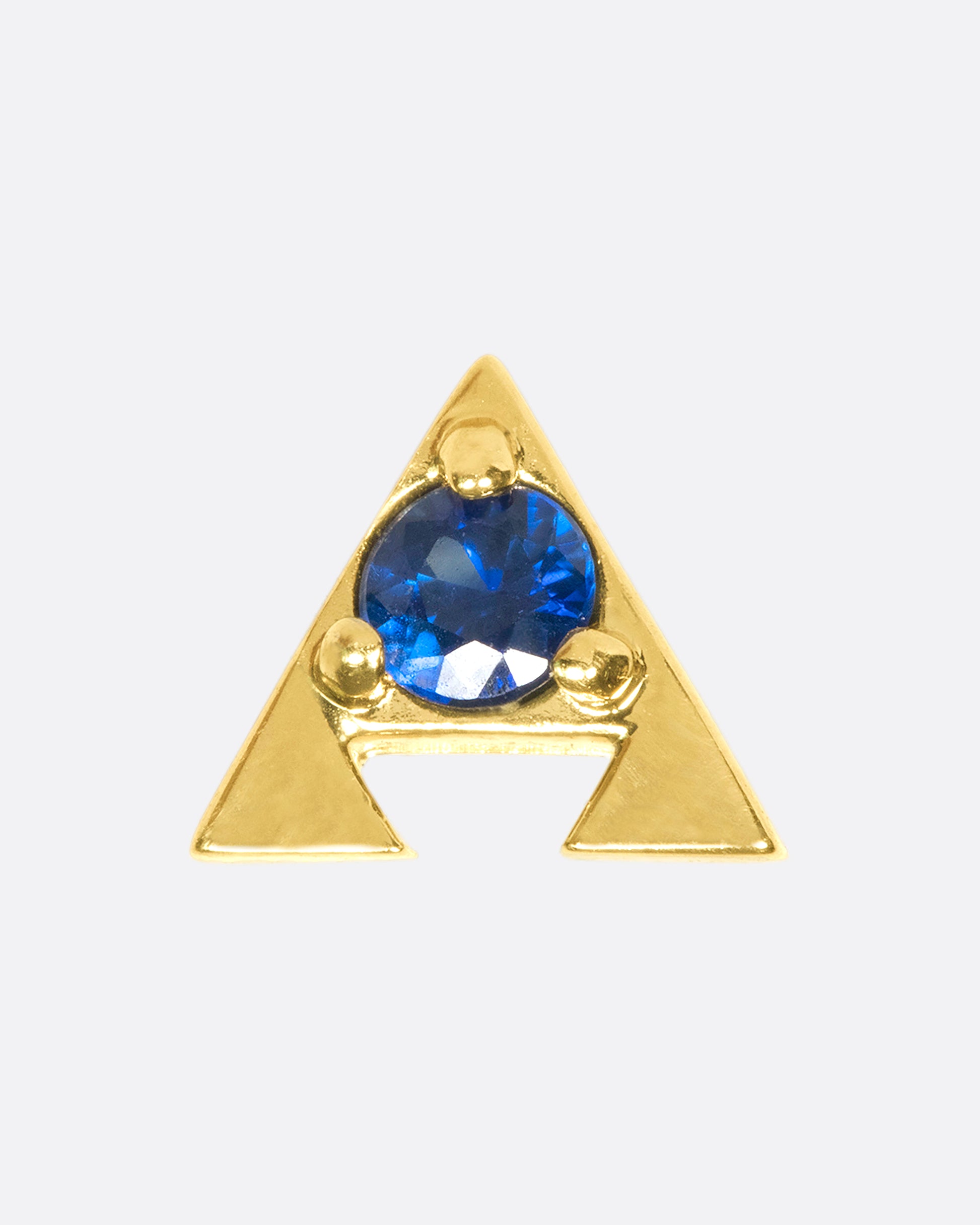 A 14k gold amulet stud with a blue sapphire in the center