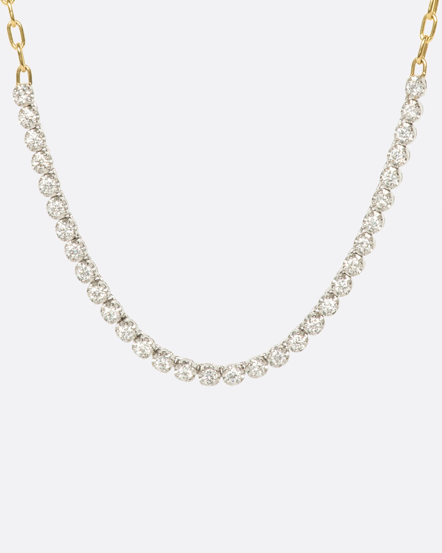 A yellow gold, oval link, chain necklace with four inches of contrasting white diamonds