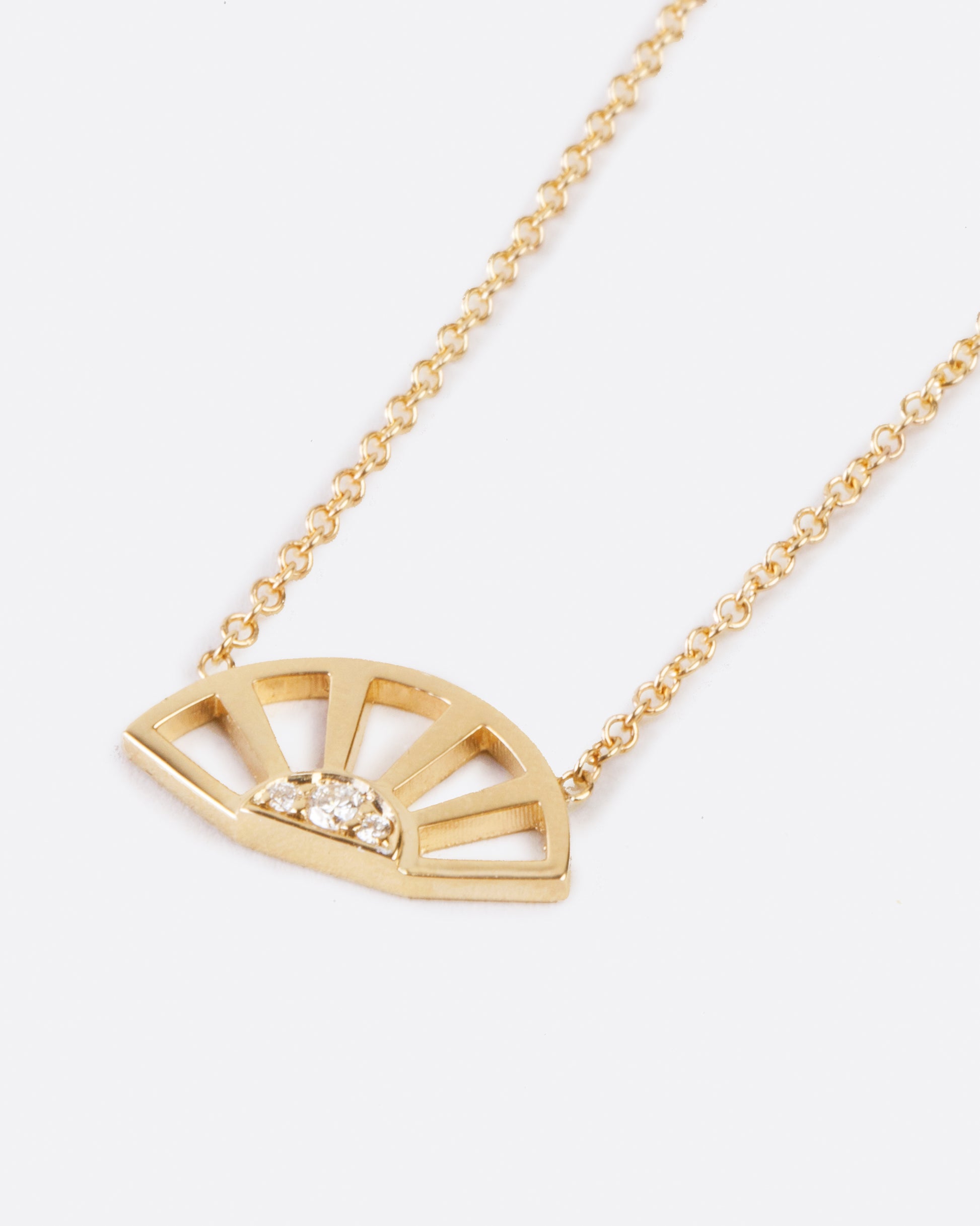 Designed to look like a sunset, this pendant necklace features three white diamonds set at the center of a yellow gold sun.