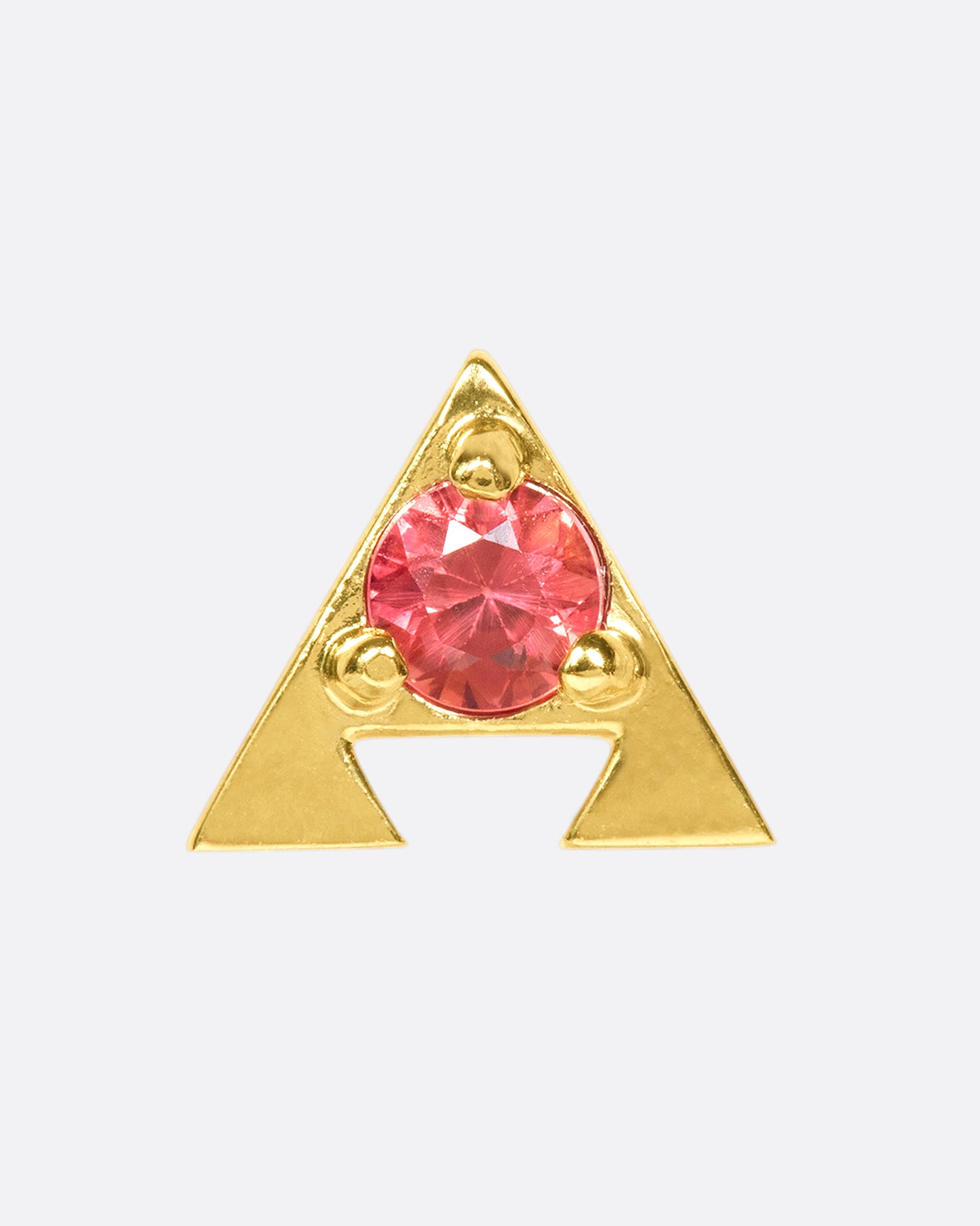 A 14k gold amulet stud with an orange sapphire in the center