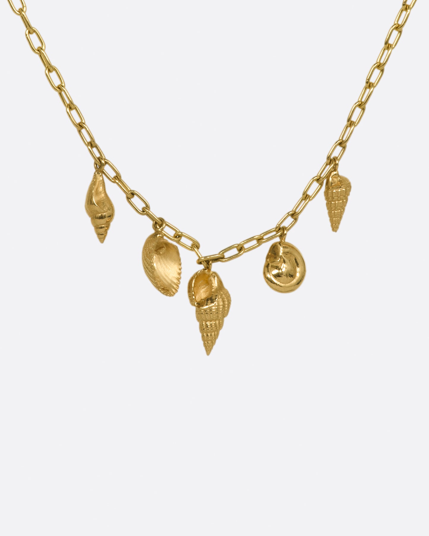 A yellow gold oval link chain necklace with five 3D shell charms in various styles. Shown from the back.