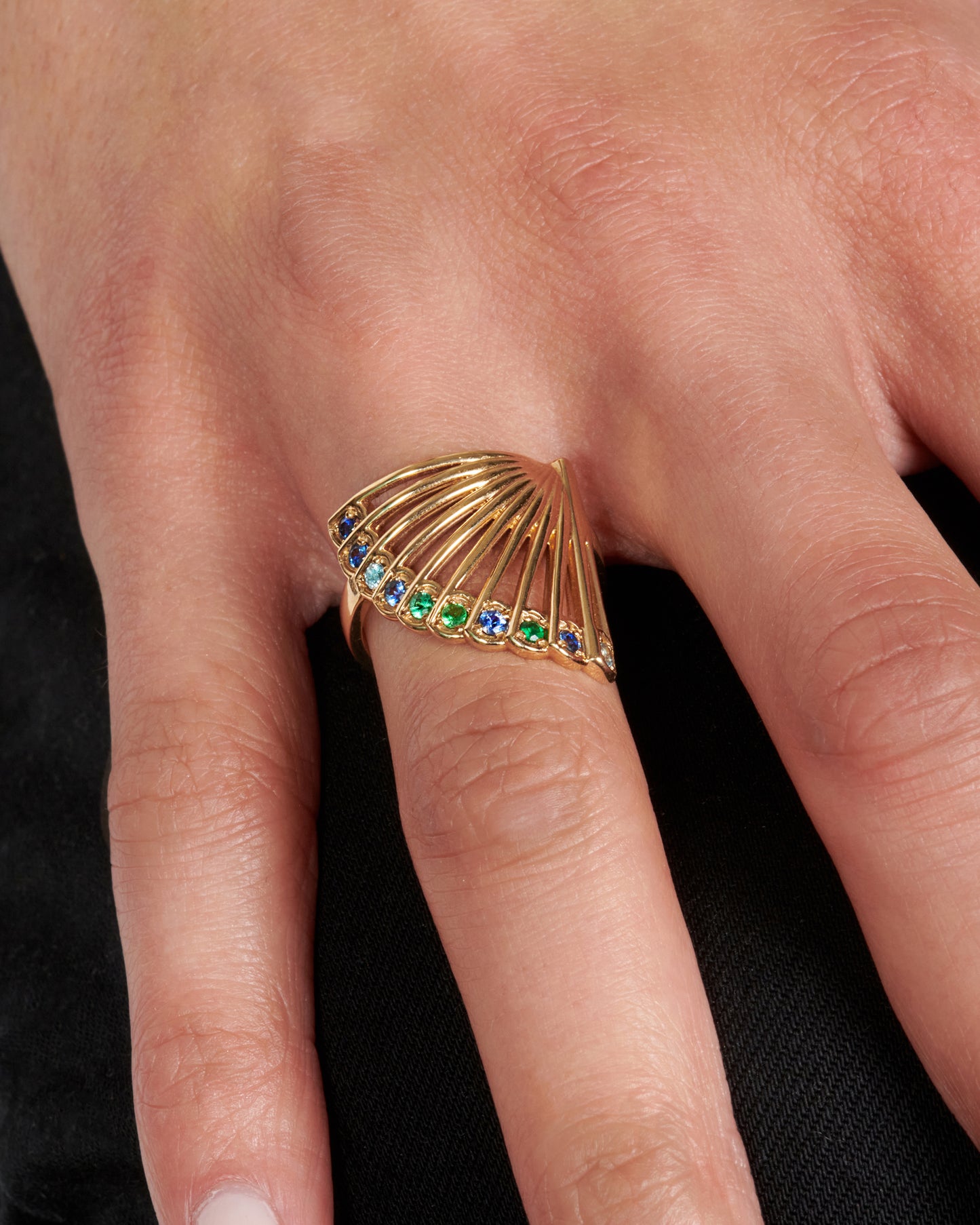 This incredible ring, modeled after the shape of a fan, features bright stones along the edge.