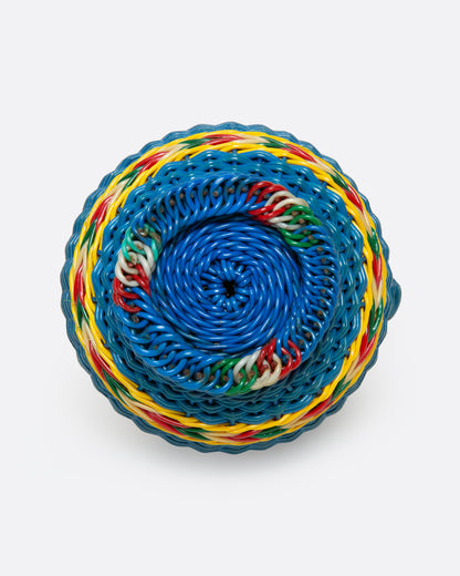 A glass Hungarian Miner's Bottle with a colorful pattern of woven electrical wire on top, shown from the bottom.