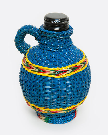 A glass Hungarian Miner's Bottle with a colorful pattern of woven electrical wire on top, shown from the side.