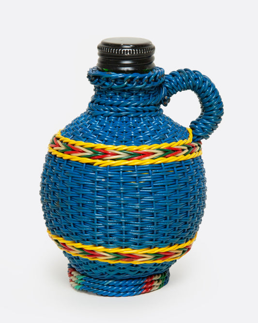A glass Hungarian Miner's Bottle with a colorful pattern of woven electrical wire on top, shown from the side.