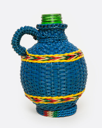 A glass Hungarian Miner's Bottle with a colorful pattern of woven electrical wire on top, shown from the side.