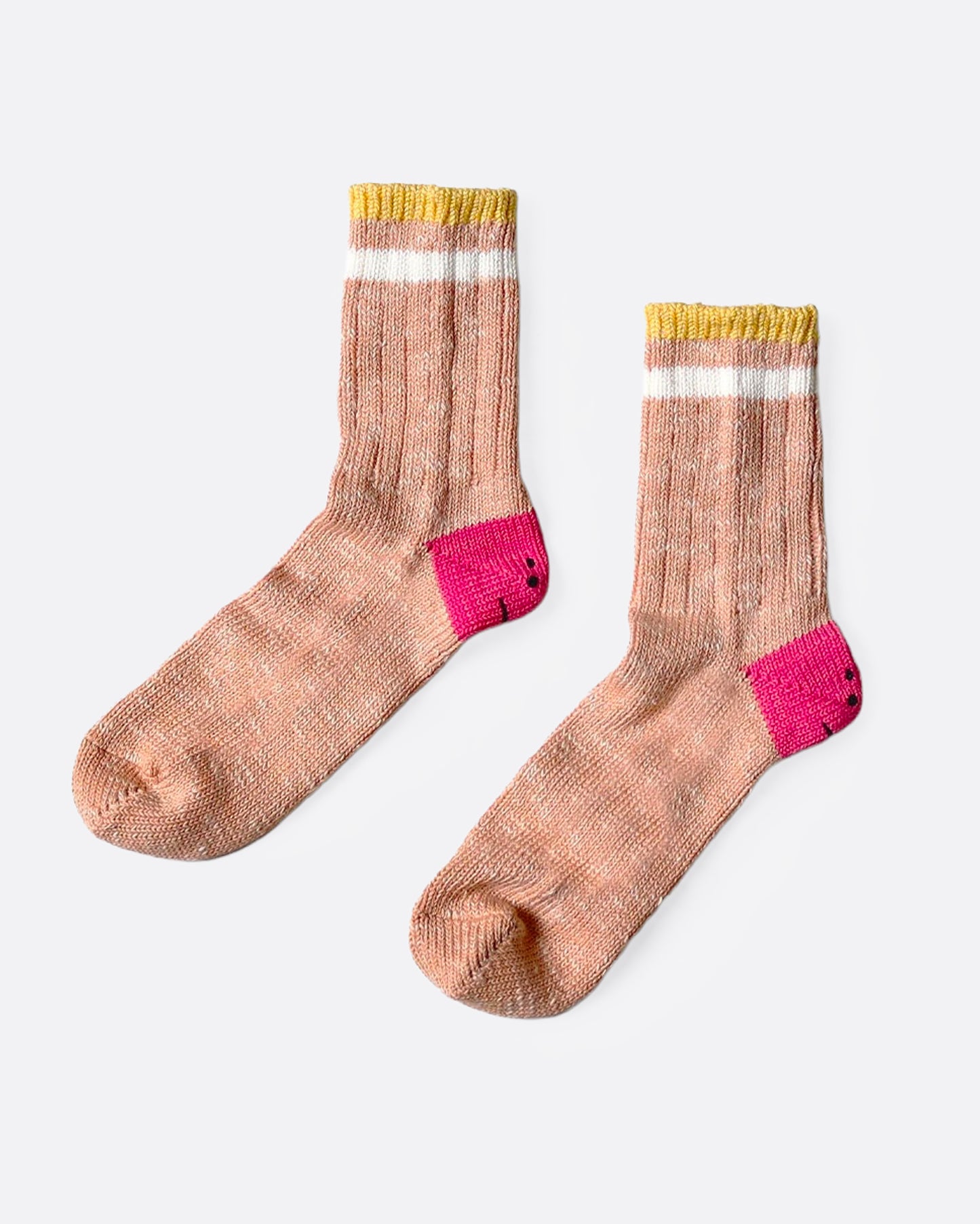 A pair of orange socks with pink smiley heels, and yellow and white stripes on each ankle. Shown from the side.