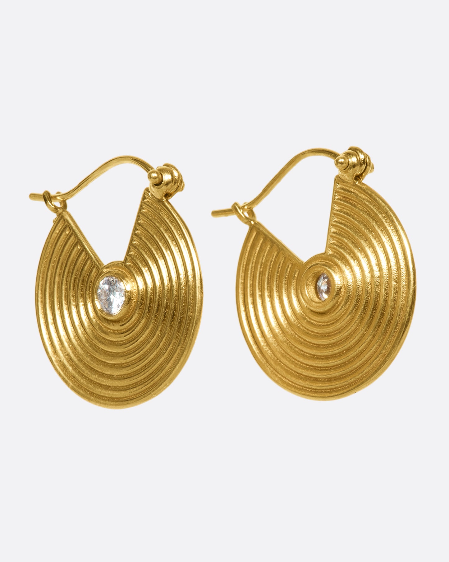 14k gold spiral hoops punctuated with white diamonds. Depending on the angle of your piercing, these may look like thin hoops or gold, ribbed discs from the front.