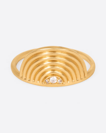 A yellow gold ring with a semi- circle spiral with three diamonds at its center. Shown from the front.