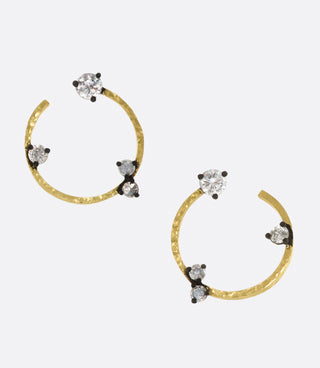 A pair of studs that mimic hoop earrings, dotted with inverted diamonds.