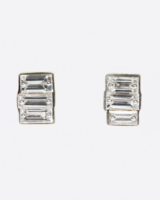 This pair of rectangular studs has three drilled baguette diamonds on each, held in place by platinum pins.