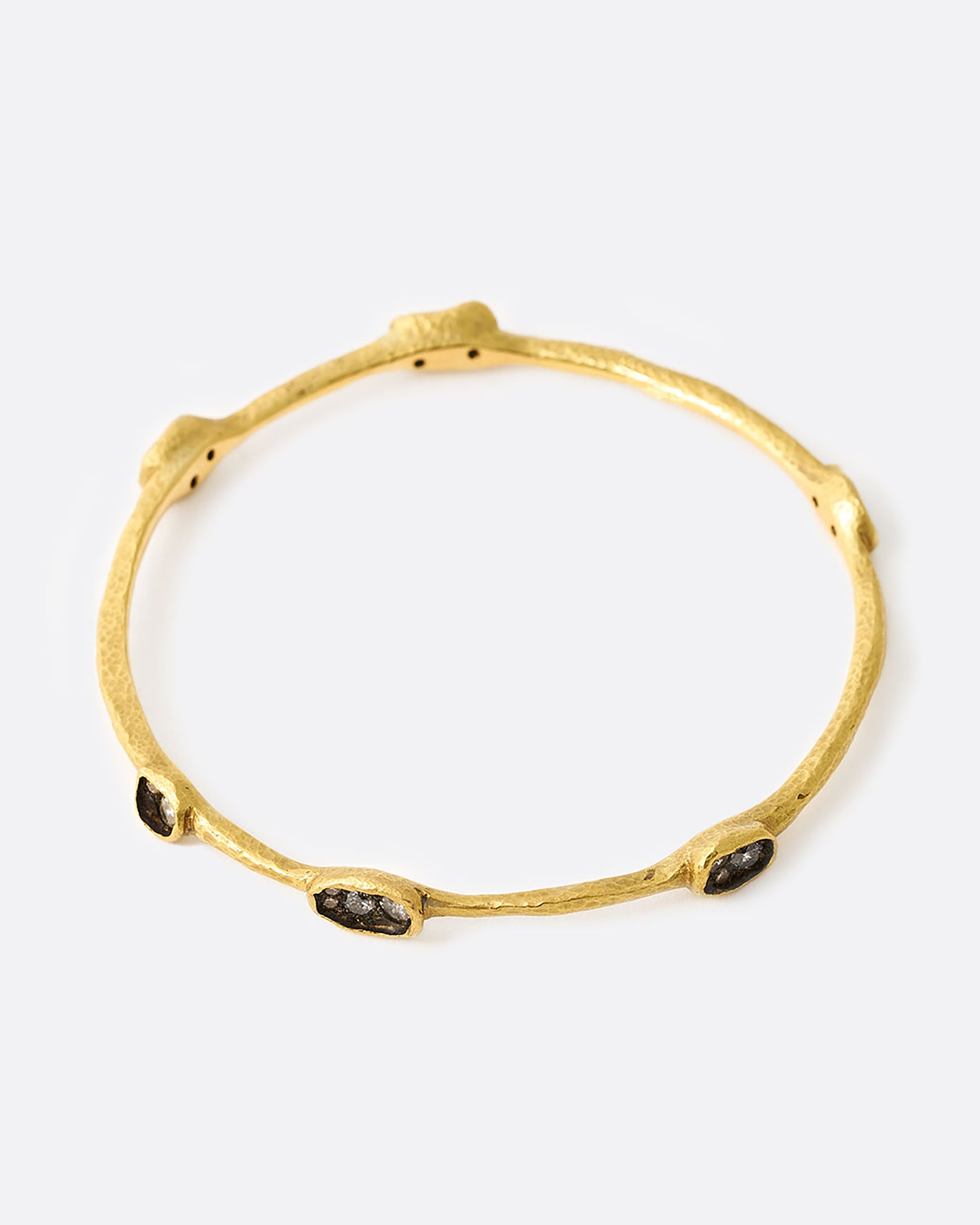 Yellow gold bangle bracelet with diamonds in oval settings, shown from the top.