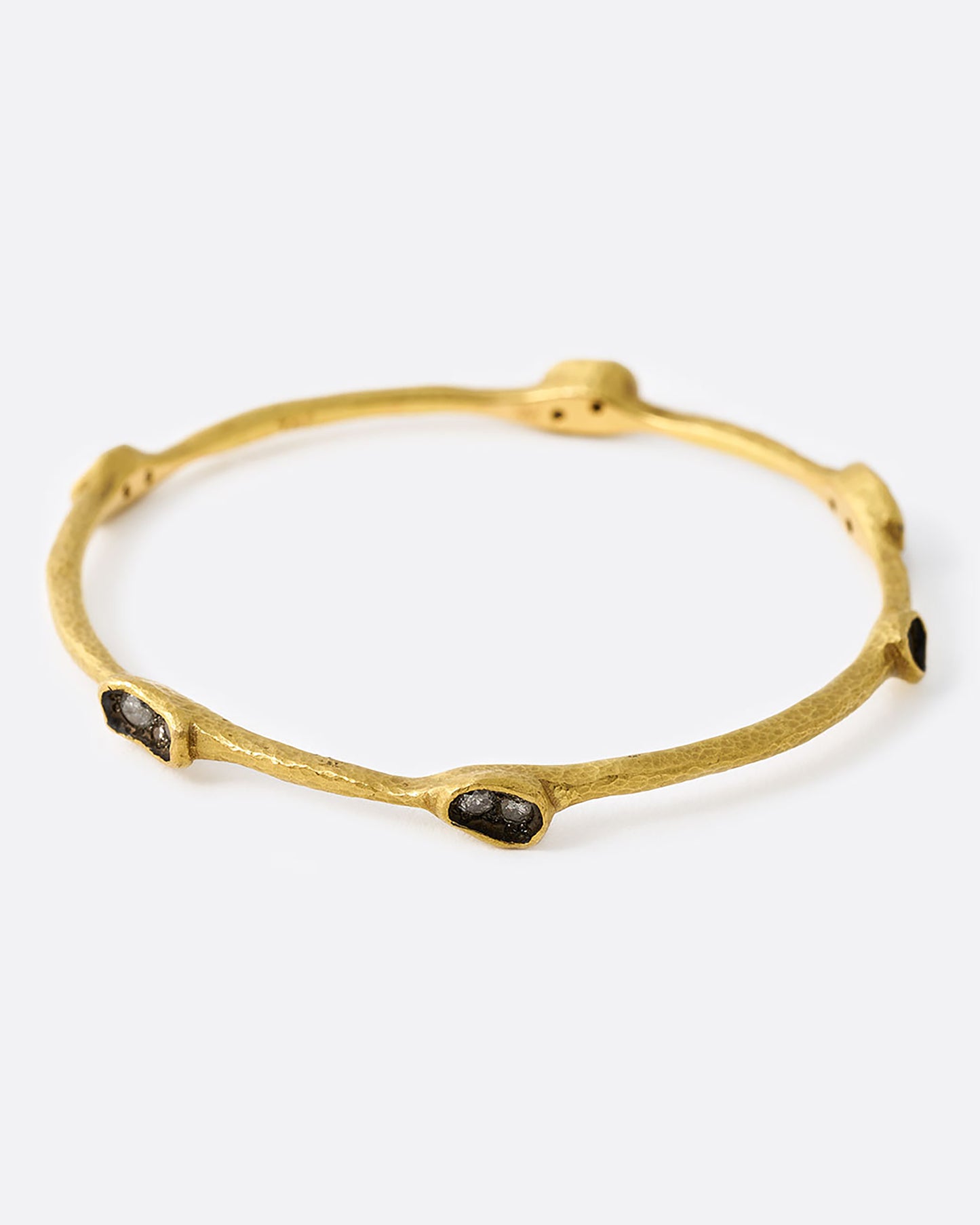 Yellow gold bangle bracelet with diamonds in oval settings, shown from the front.