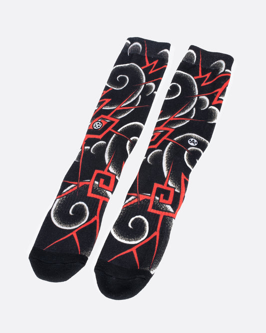 Black socks with white and red rounded and geometric swirl patterns. View from the front.
