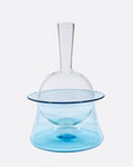 A blue glass decanter that sits in an ice bucket.