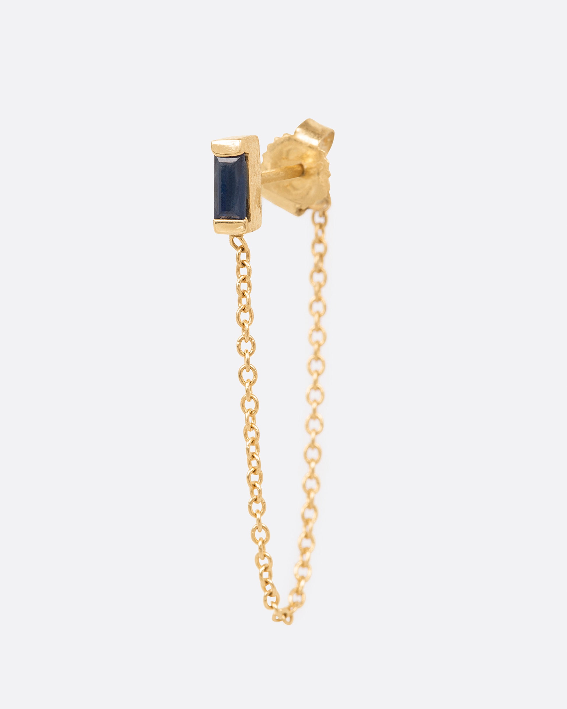 A channel set sapphire baguette stud punctuated with a 1" chain drop.