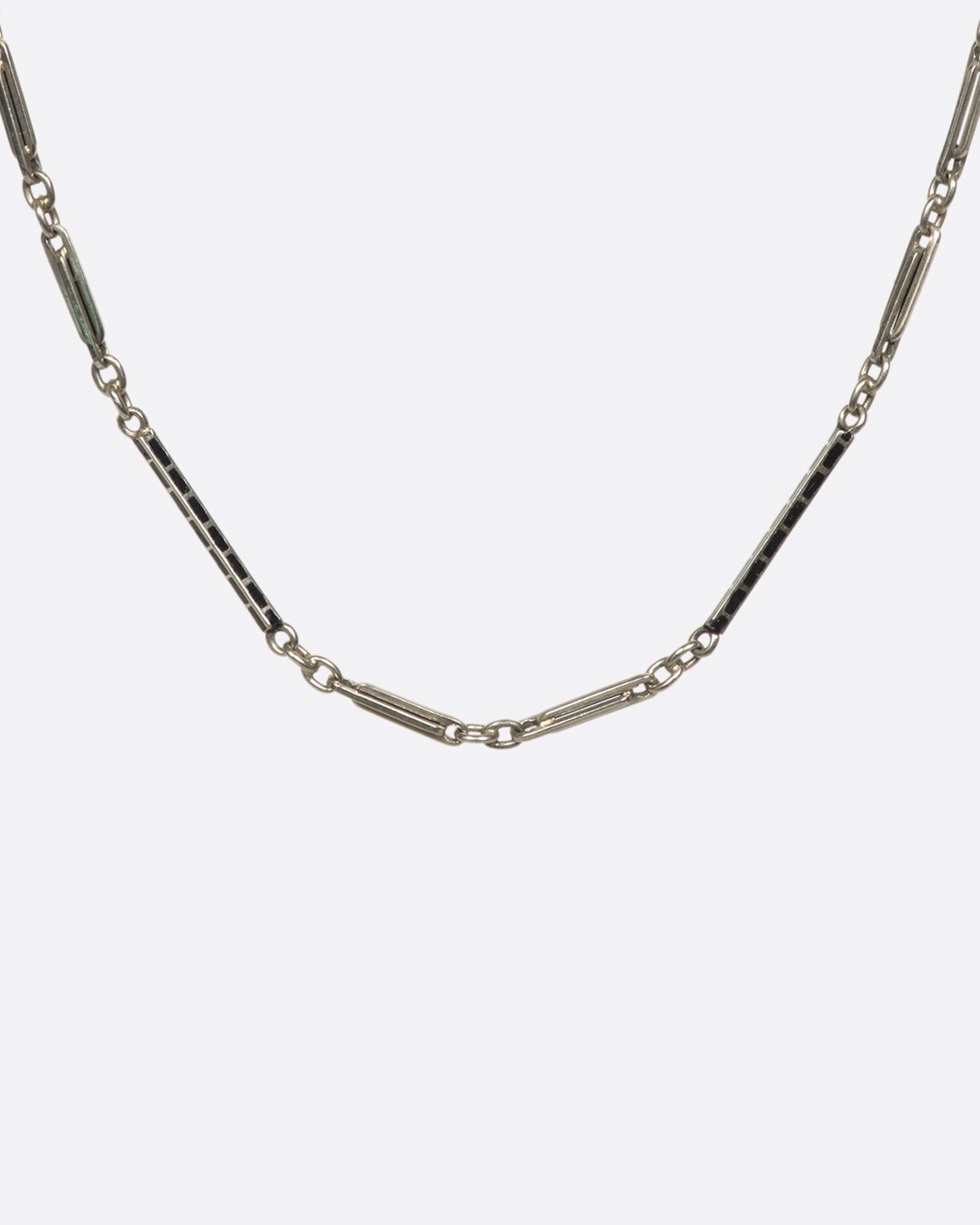 A vintage 14K white gold bar-link chain necklace with black enamel alternating throughout. Measuring just under 14 inches, this a dainty choker for someone with a slender neck.