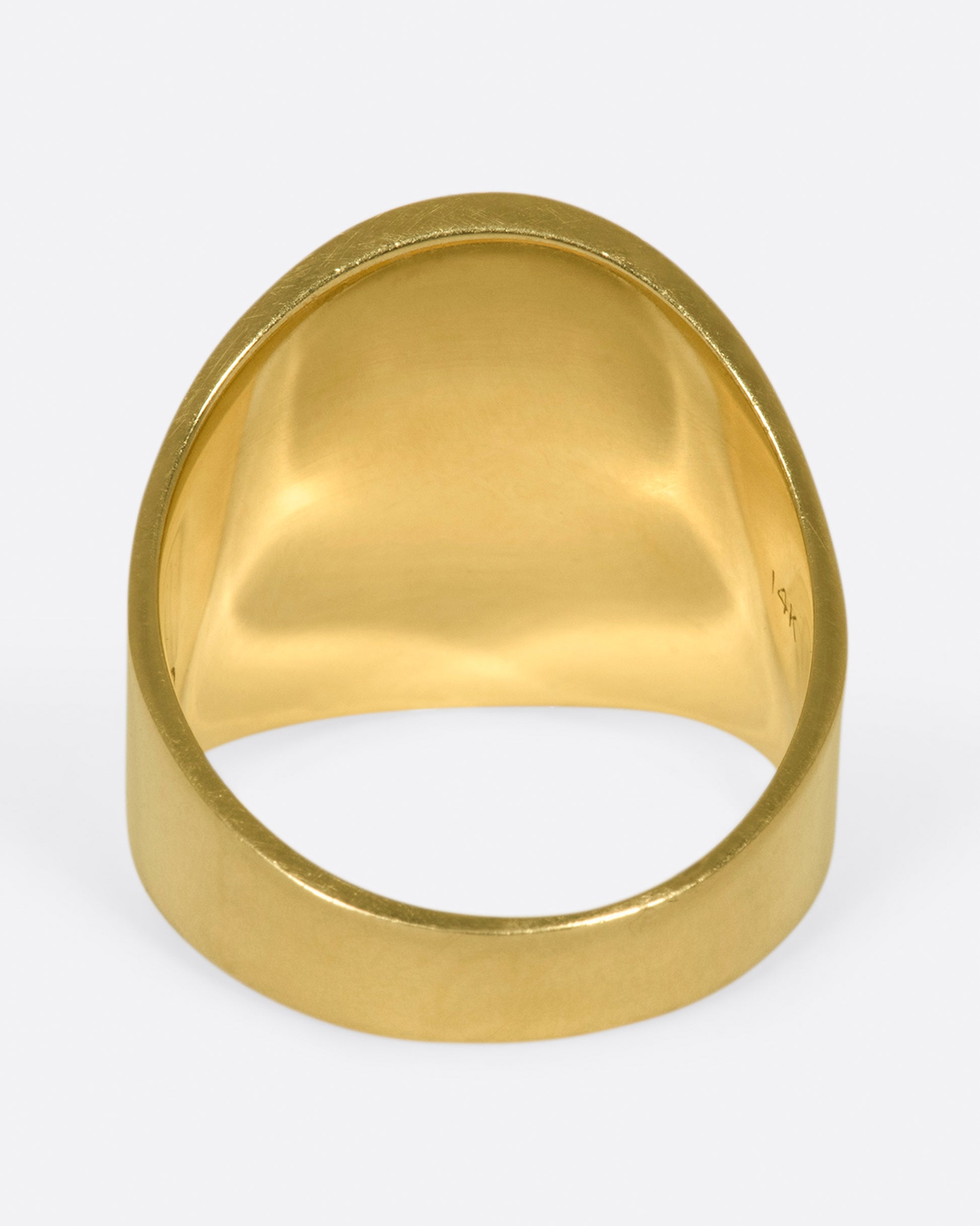 A vintage gold ring with a curved face.