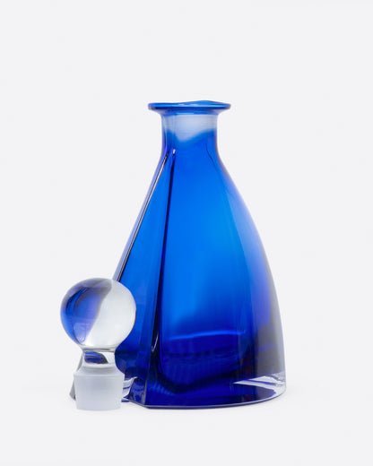 Vintage blue glass decanter, standing with the stopper beside it