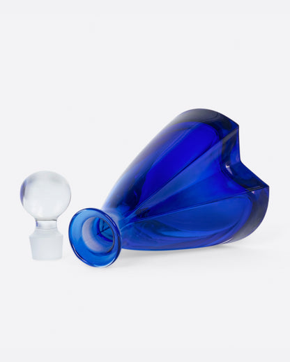 Vintage blue glass decanter laid on its side with the stopper out