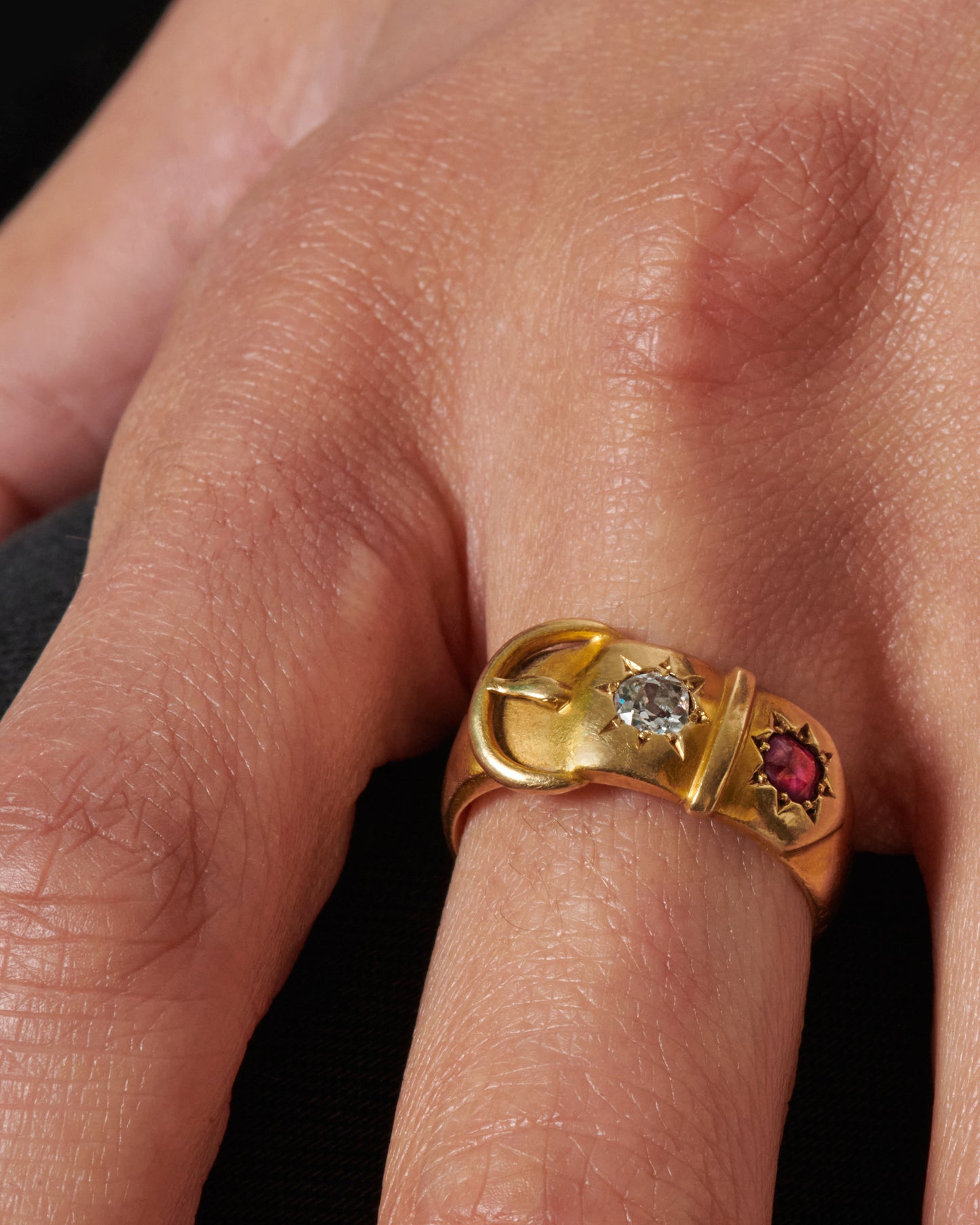 Dating back 1891 in Birmingham, England, this buckle ring is buttery soft with an old mine cut diamond and ruby.