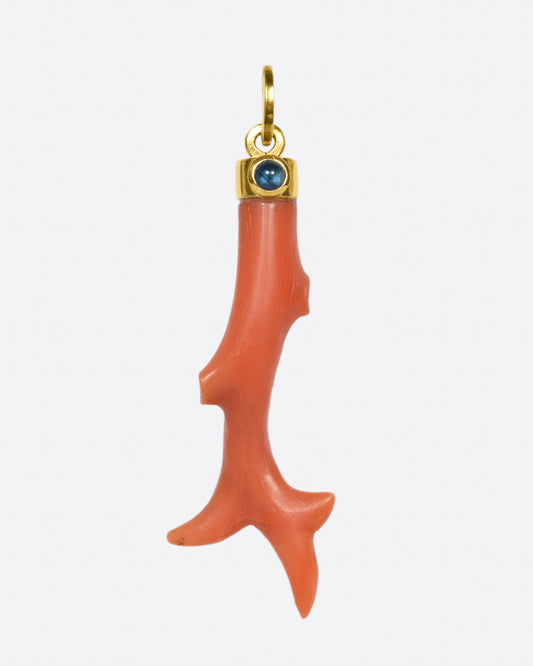 A piece of antique coral in a contemporary setting, accented with a blue sapphire cabochon.