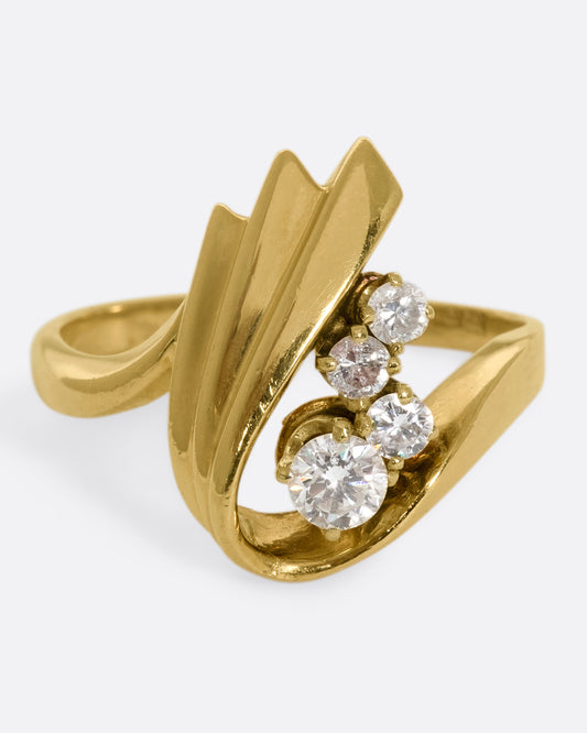 A vintage 14k gold U-shaped ring with four round diamonds resting in the center.