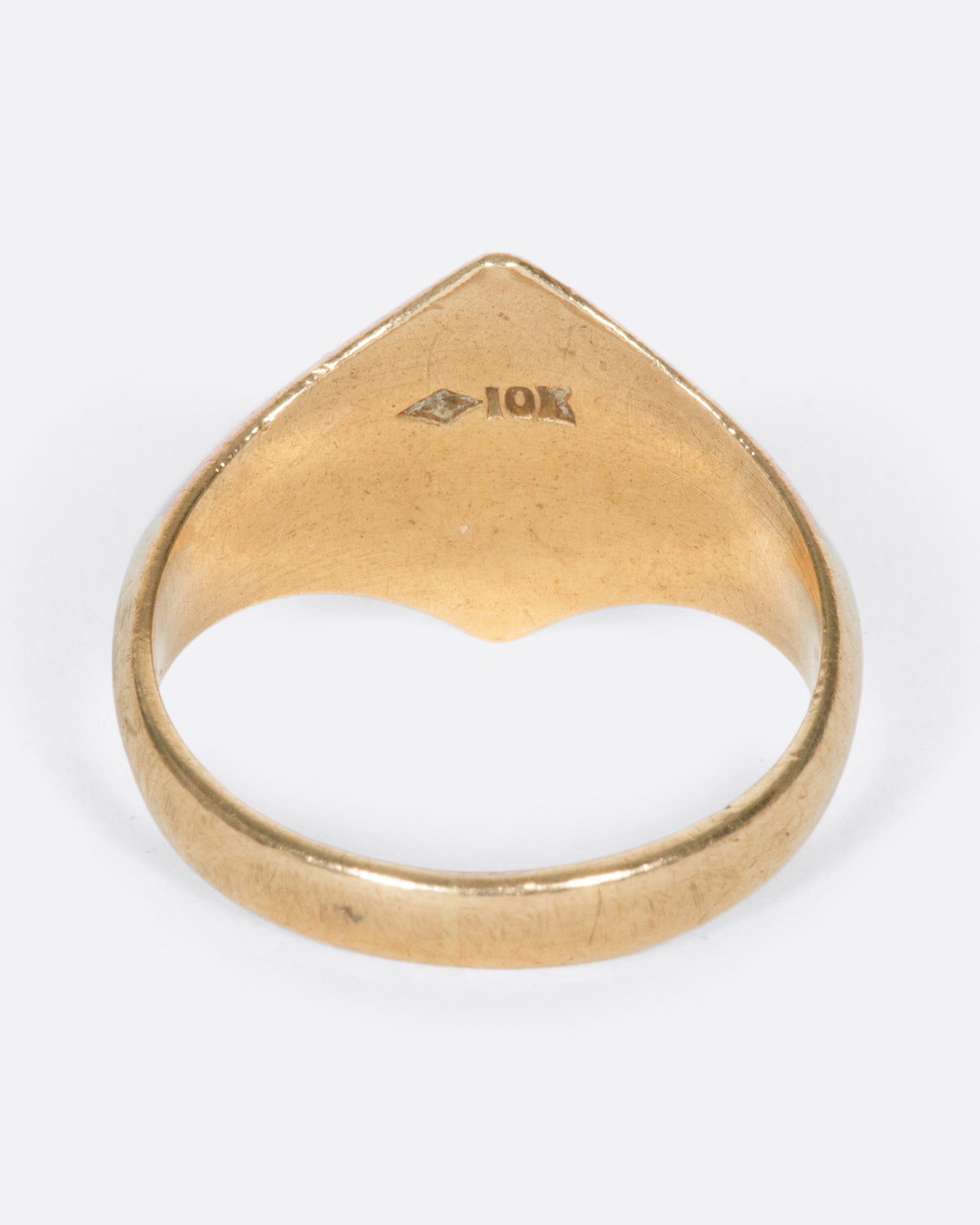 A vintage yellow gold signet ring with a diamond shaped face and the initials EB engraved on the front.