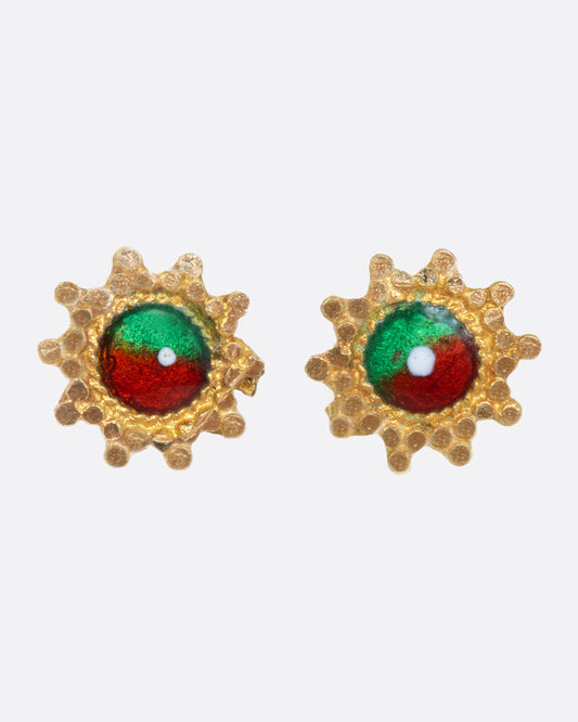 A pair of yellow gold dotted starburst earrings with round centers that are half red enamel and half green.