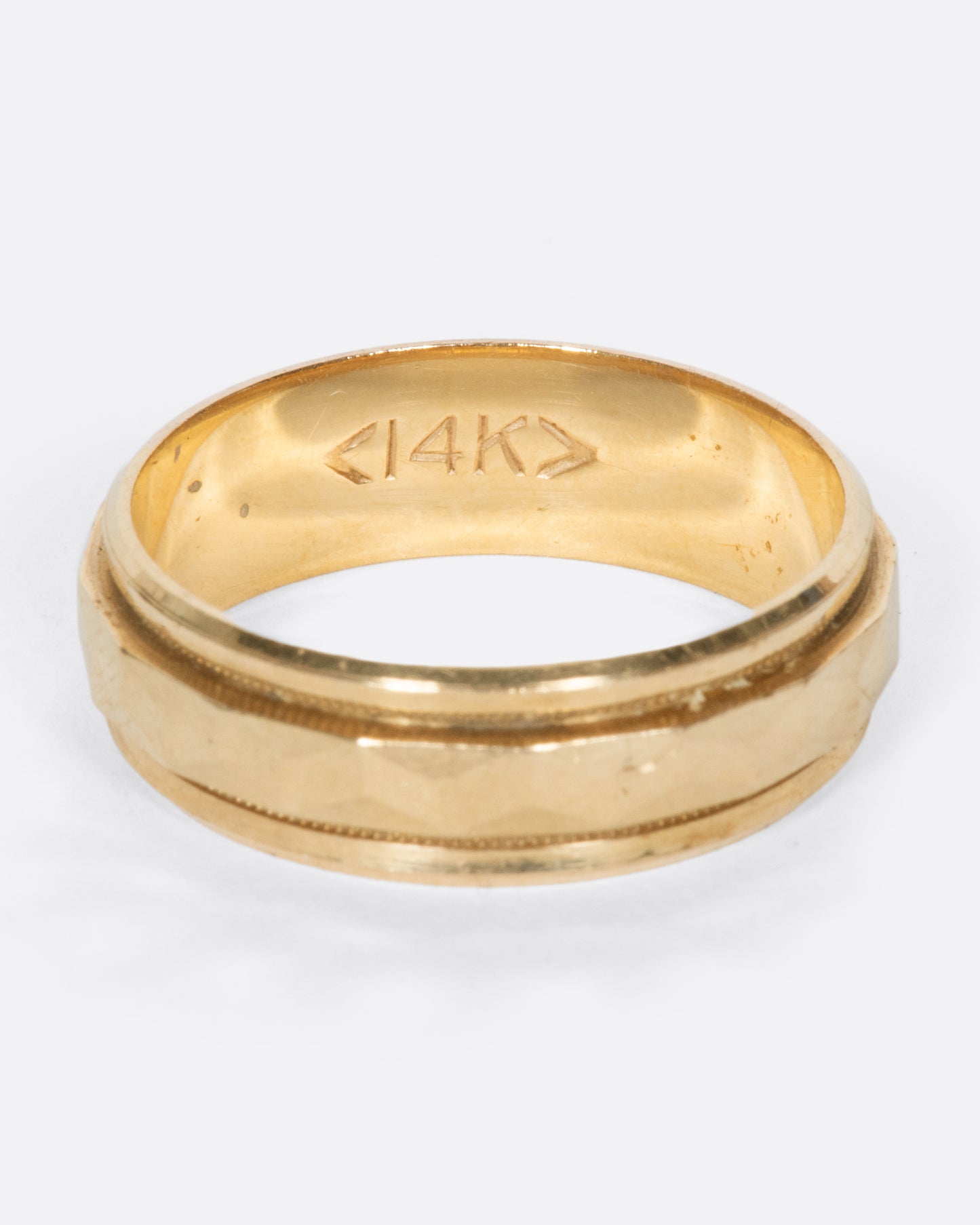 A vintage yellow gold band with geometric faceting down the center.