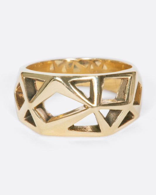 A vintage yellow gold ring with a raised, faceted face that has geometric cutouts throughout.