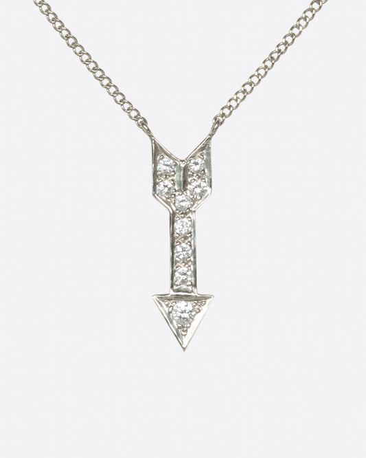 A narrow curb chain is fixed directly to either side of this diamond-lined pendant.