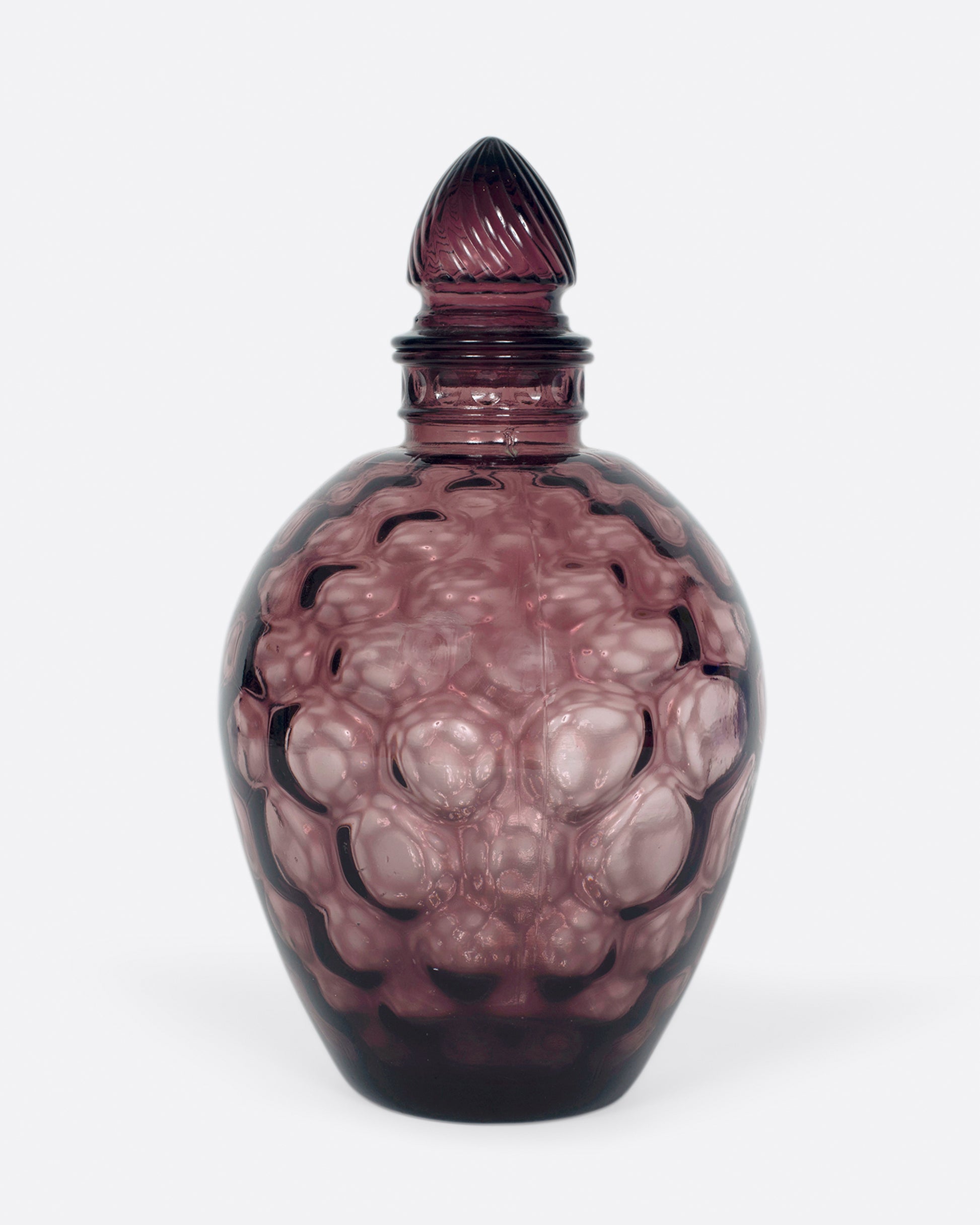 A dark plum, bubble glass bottle with an acorn-shaped stopper.