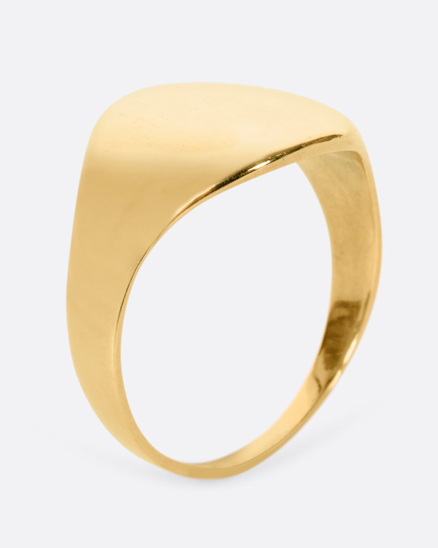 A vintage yellow gold signet ring with a round face and soft shoulders.