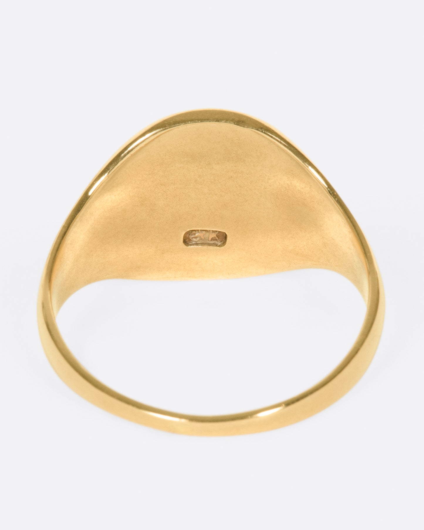 A vintage yellow gold signet ring with a round face and soft shoulders.