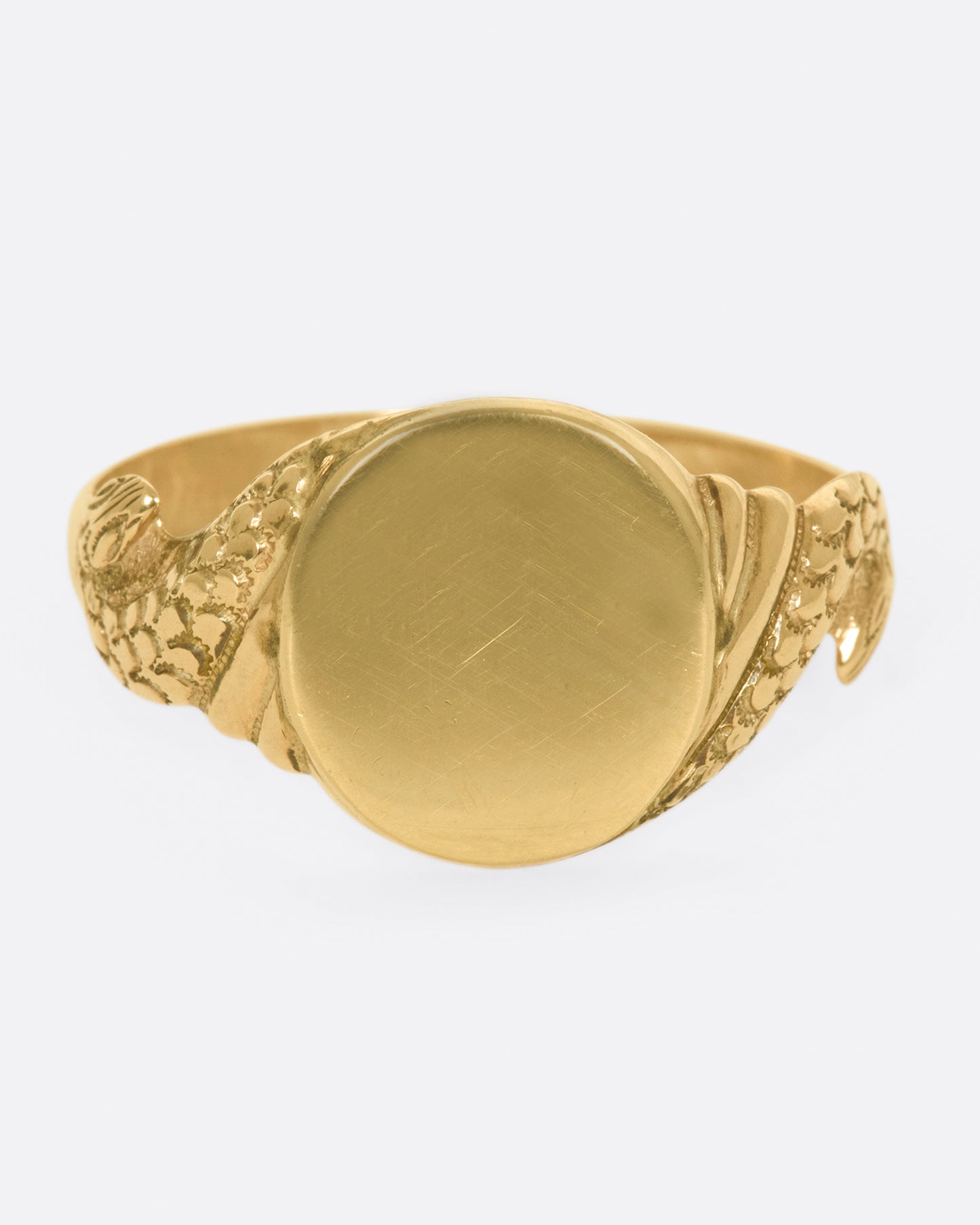 A classic, blank signet ring with carved snakes swirling around the band.