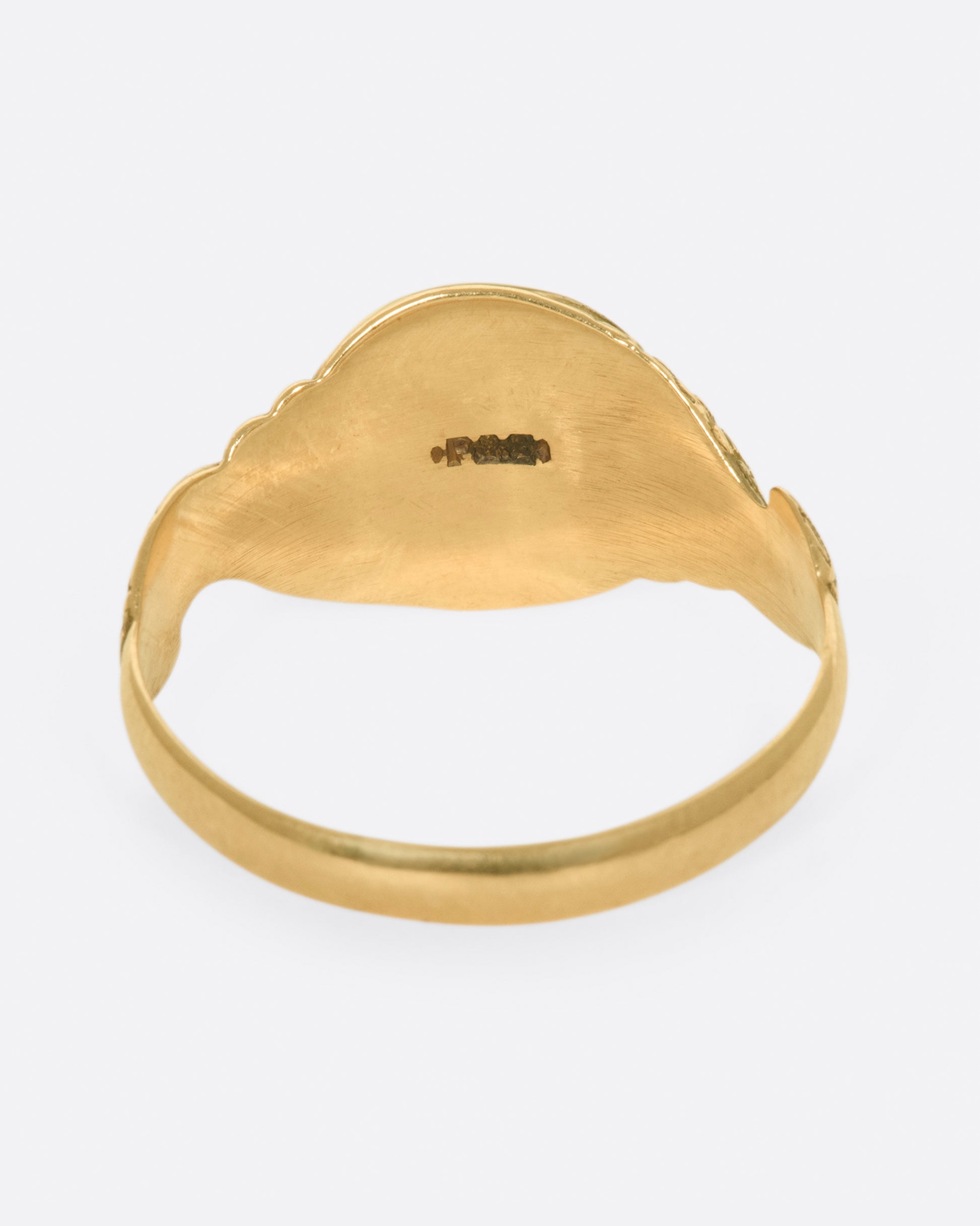 A classic, blank signet ring with carved snakes swirling around the band.