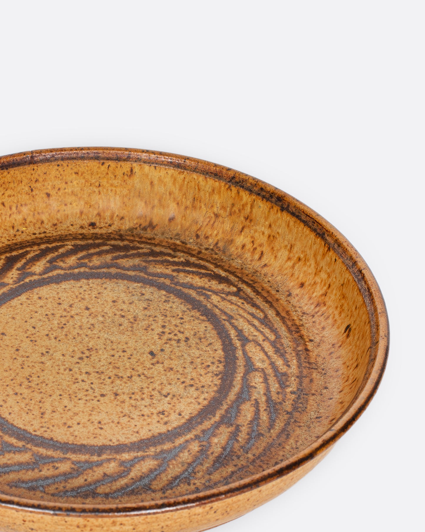 A vintage studio-made ceramic serving platter of generous size, with a swirling center design.