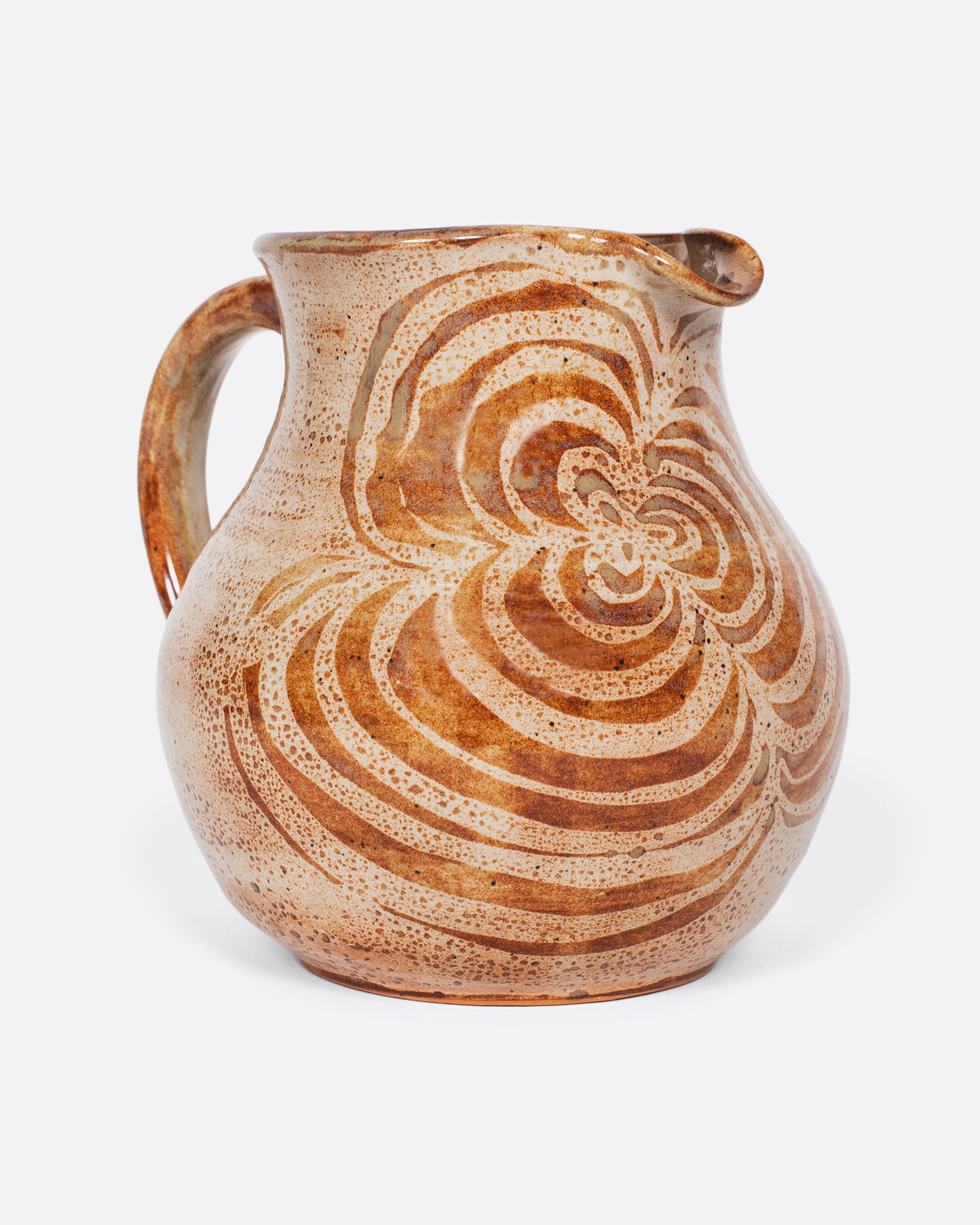 A studio-made, beautifully weighted, rounded ceramic pitcher with a brown swirl design that mimics a blossoming flower.