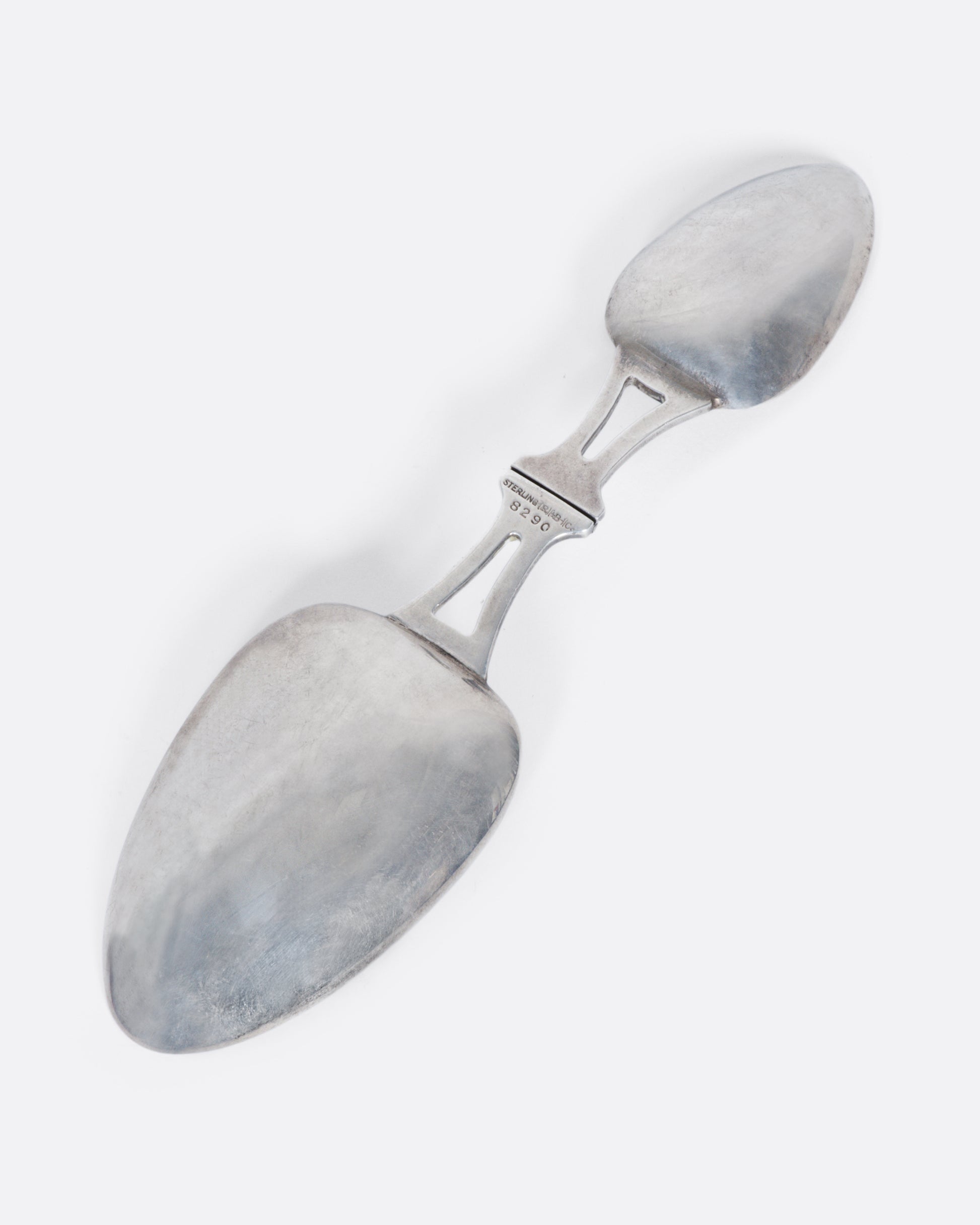 A sterling silver folding spoon with a teaspoon on one side and a tablespoon on the other.