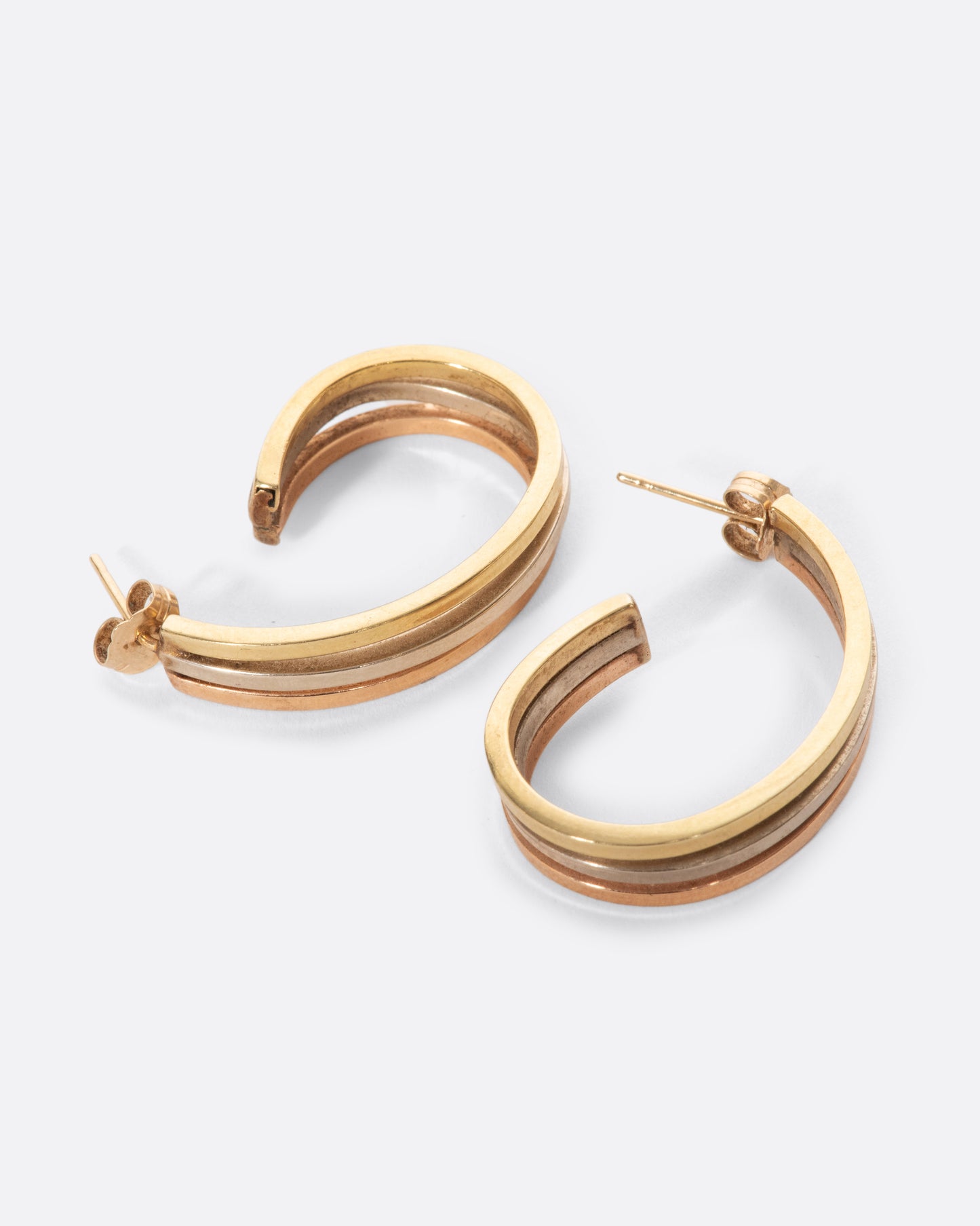 A pair of vintage yellow, white, and rose gold earrings. They curl elegantly under your ear, offering exceptional wearability with the beautiful mix of metals.