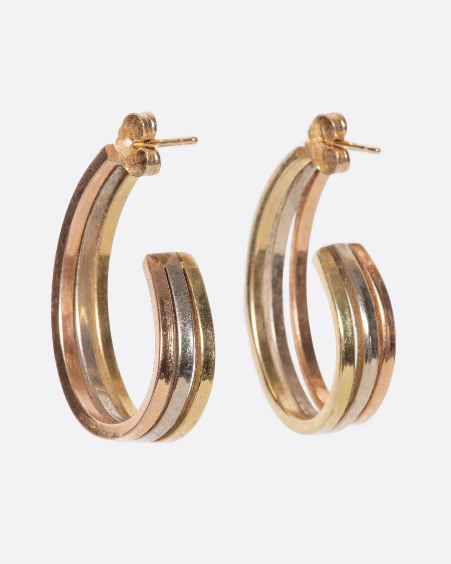 A pair of vintage yellow, white, and rose gold earrings. They curl elegantly under your ear, offering exceptional wearability with the beautiful mix of metals.