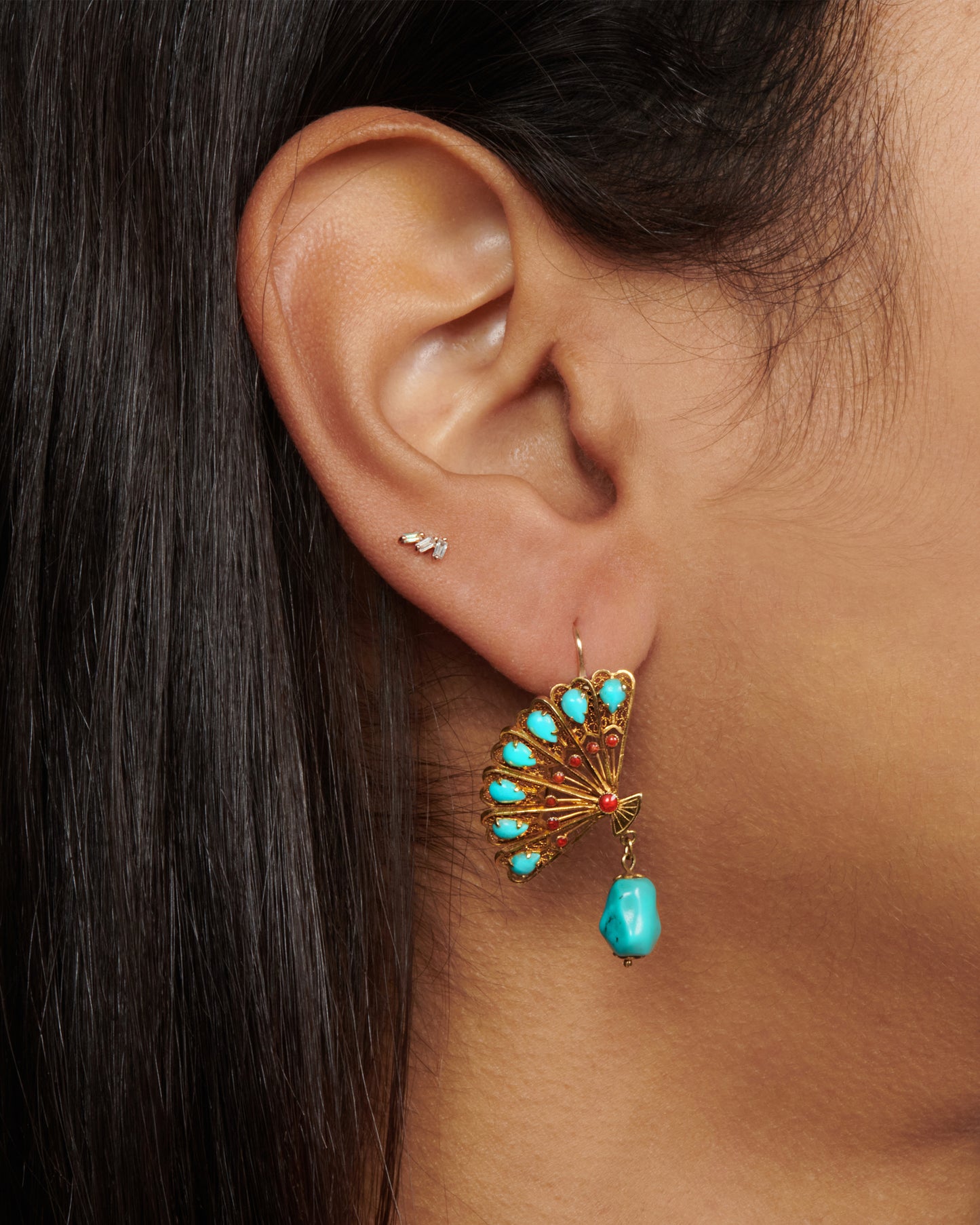 A pair of beautiful gold fan earrings with turquoises and red enamel details. We love these for their vintage vibe, versatile color palette, and sense of balance the hanging stones creates.
